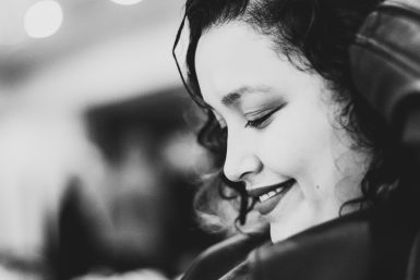Black and white photo of a Latina woman looking down and smiling.